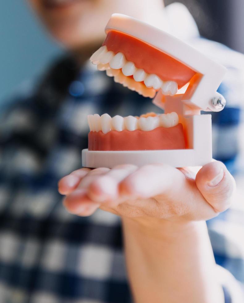 Stomatology concept, partial portrait of girl with strong white teeth looking at camera and smiling, fingers near face. Closeup of young woman at dentist's, studio, indoors photo