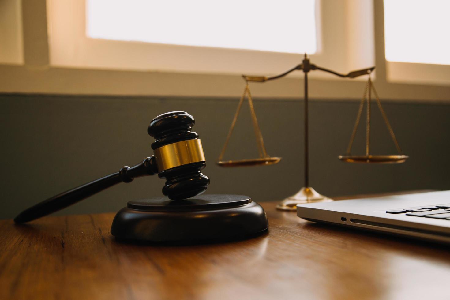 Business and lawyers discussing contract papers with brass scale on desk in office. Law, legal services, advice, justice and law concept picture with film grain effect photo