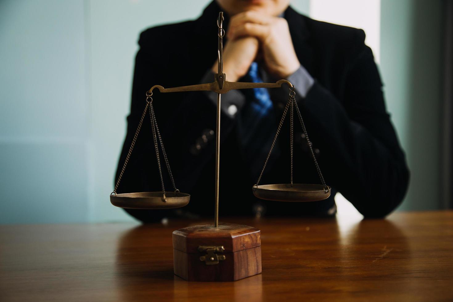 Business and lawyers discussing contract papers with brass scale on desk in office. Law, legal services, advice, justice and law concept picture with film grain effect photo