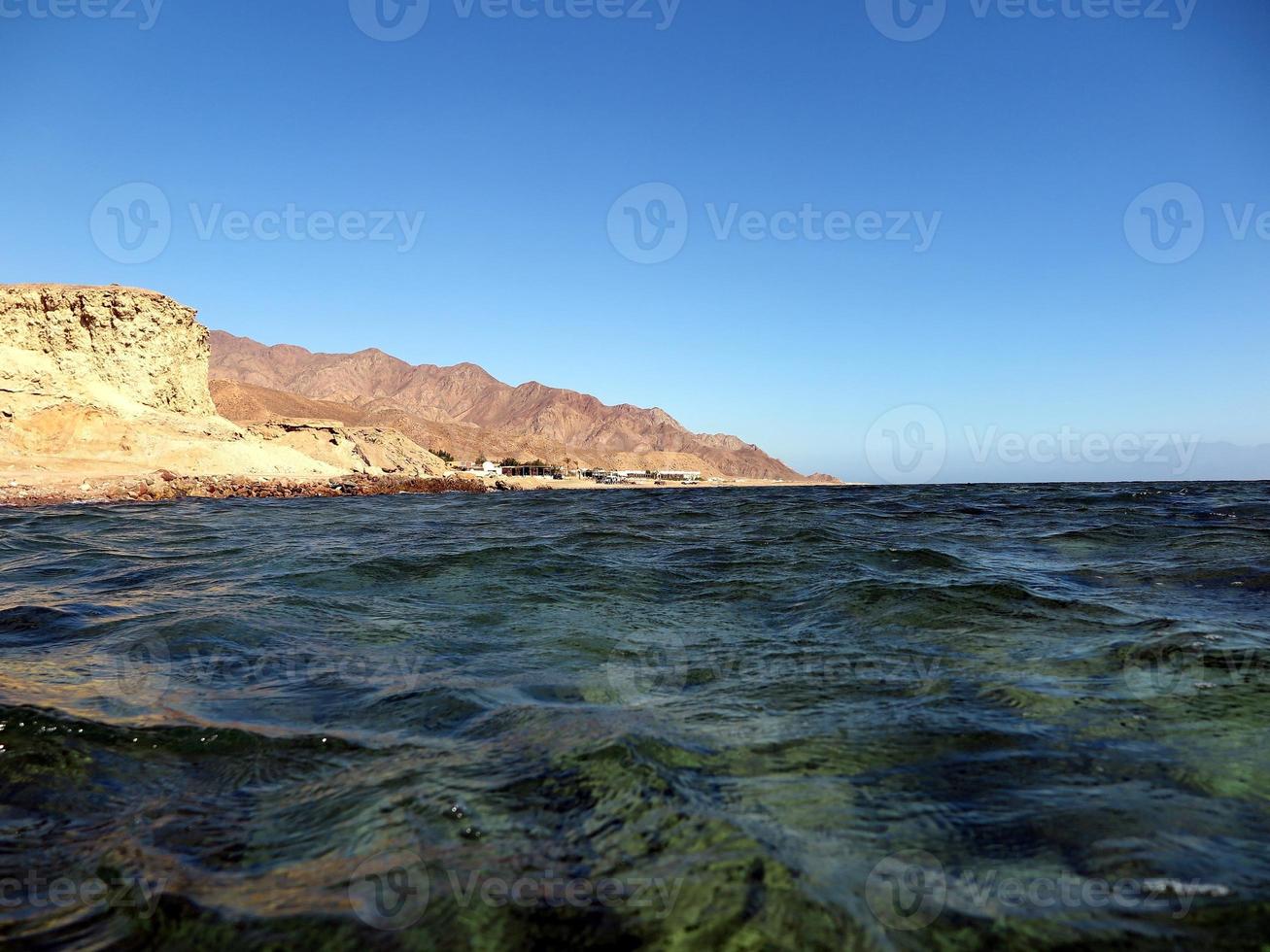 Scenic view of red sea against sky and mountains photo