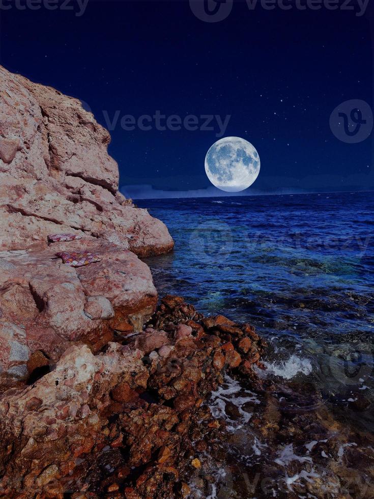 Scenic view of red sea at night with full moon above the sea and mountains photo