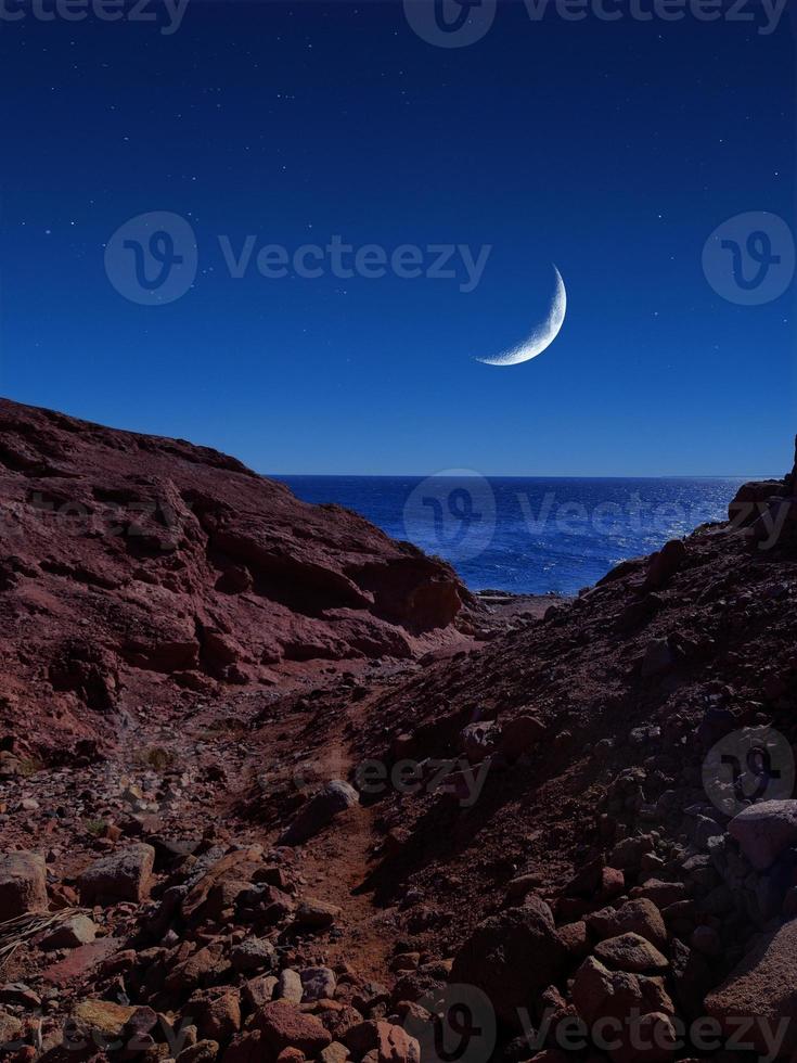 Scenic view of red sea at night with full moon above the sea and mountains photo