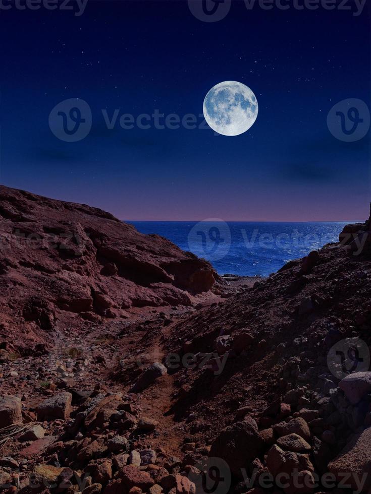 Scenic view of red sea at night with full moon above the sea and mountains photo