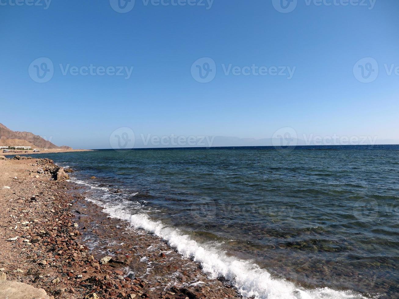 Scenic view of red sea against sky and mountains photo