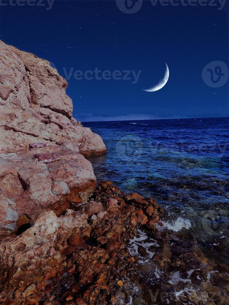 Scenic view of red sea at night with full moon above the sea and mountains photo