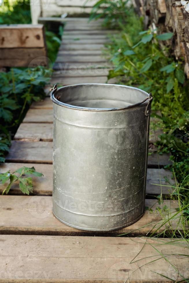 iron bucket with water in the country in the summer photo