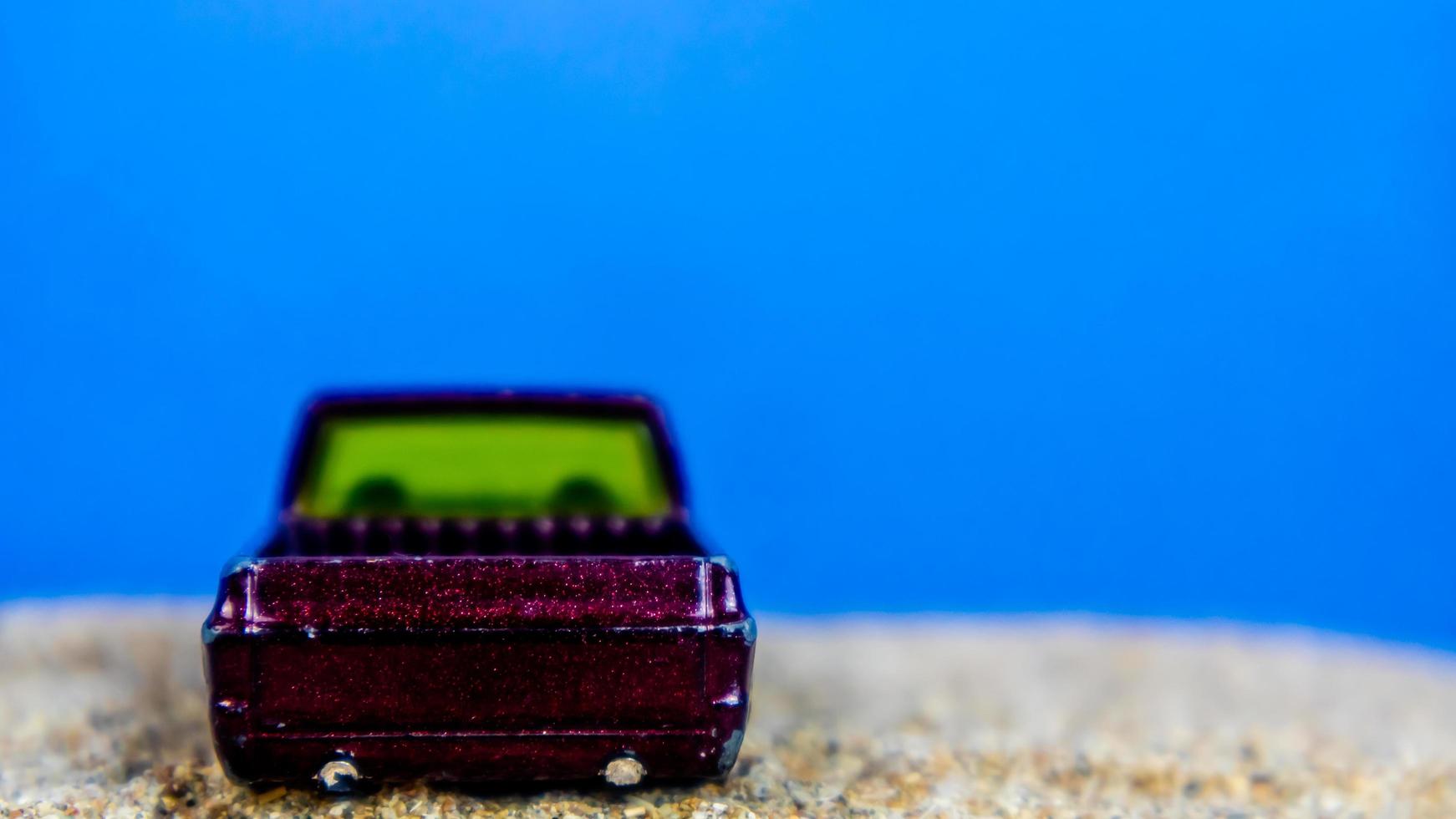 Minahasa, Indonesia  Monday, 12 December 2022, toy car on the sand on a blue background photo