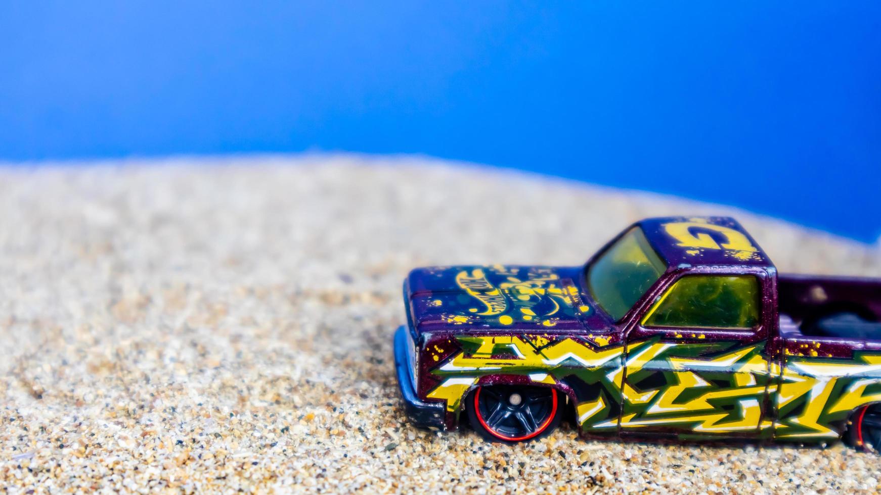 Minahasa, Indonesia  Monday, 12 December 2022, toy car on the sand on a blue background photo