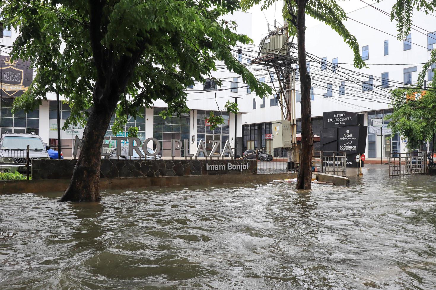 Semarang, December 2022. Some people are walking through the flood that hit the Poncol train station area and some residents are preparing to evacuate. vehicles hit the flood photo