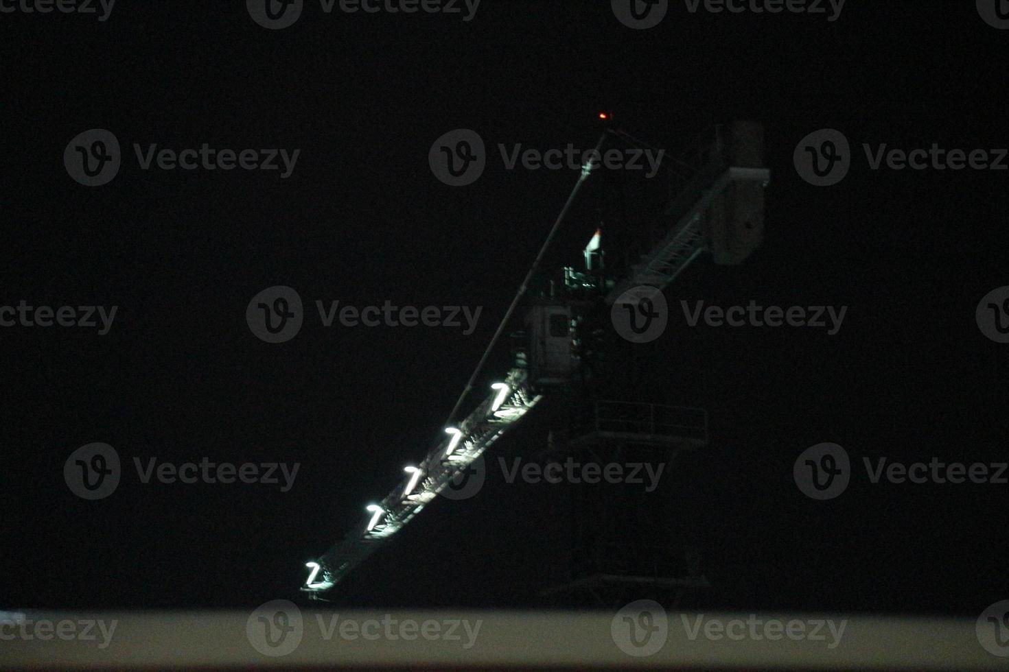 Tower crane working at night. the lighting is not too much, photo