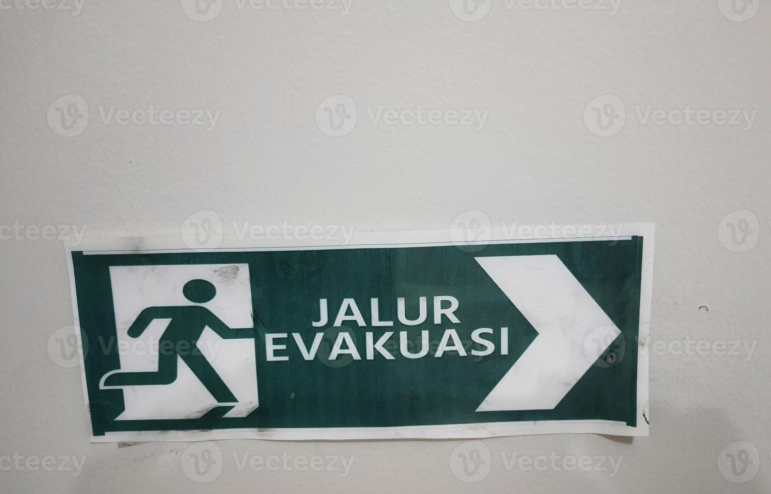 Jalur Evakuasi Evacuation Route sign in green color photo