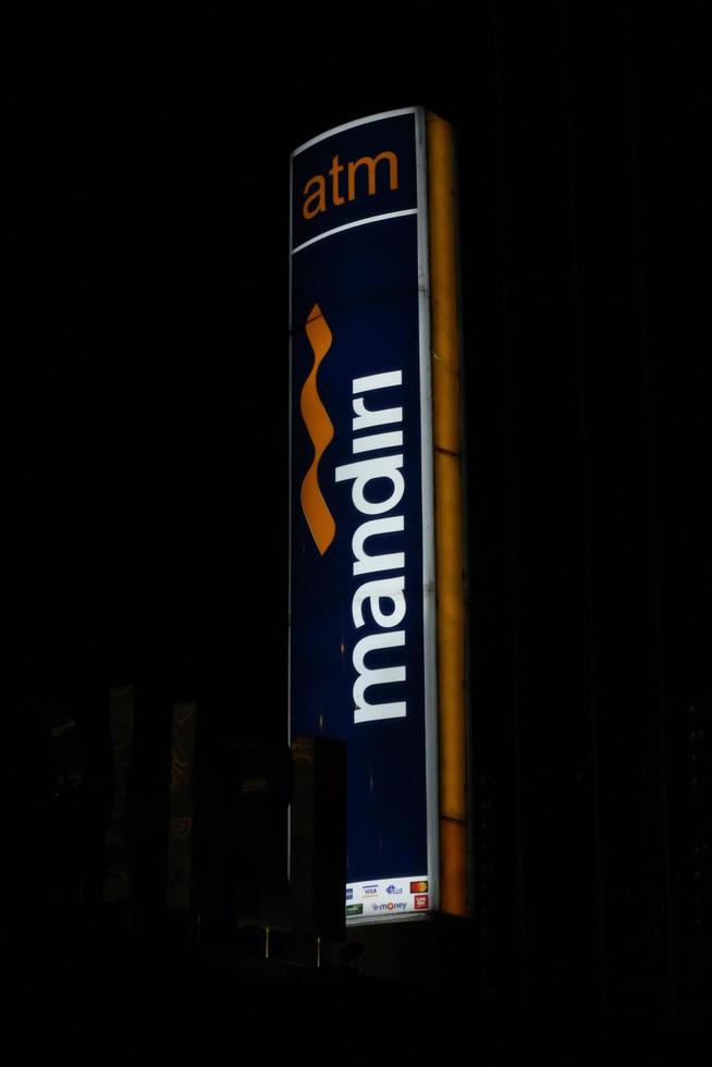 Bekasi, Indonesia in July 2022. The logo of Bank Mandiri shining brightly at night against the dark night sky. photo