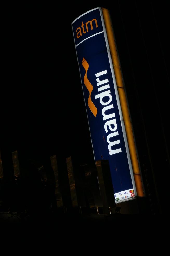 Bekasi, Indonesia in July 2022. The logo of Bank Mandiri shining brightly at night against the dark night sky. photo