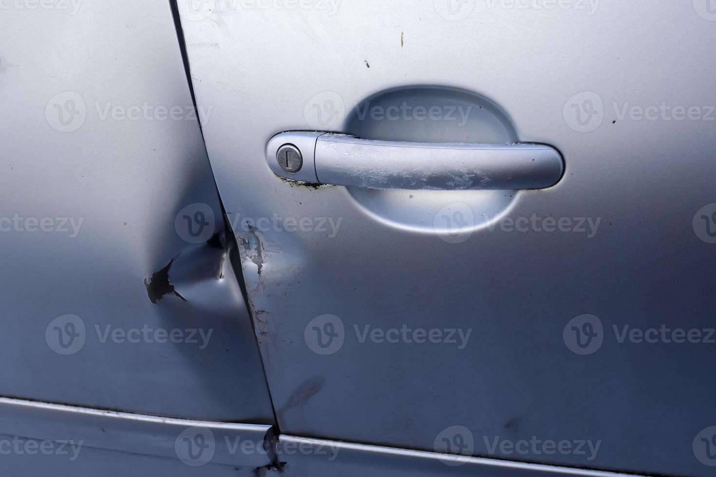 Car door with break-in marks from a crowbar near the handle. photo