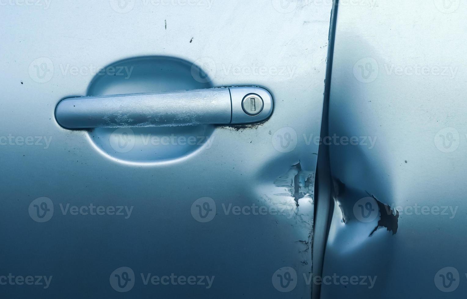 Car door with break-in marks from a crowbar near the handle. photo