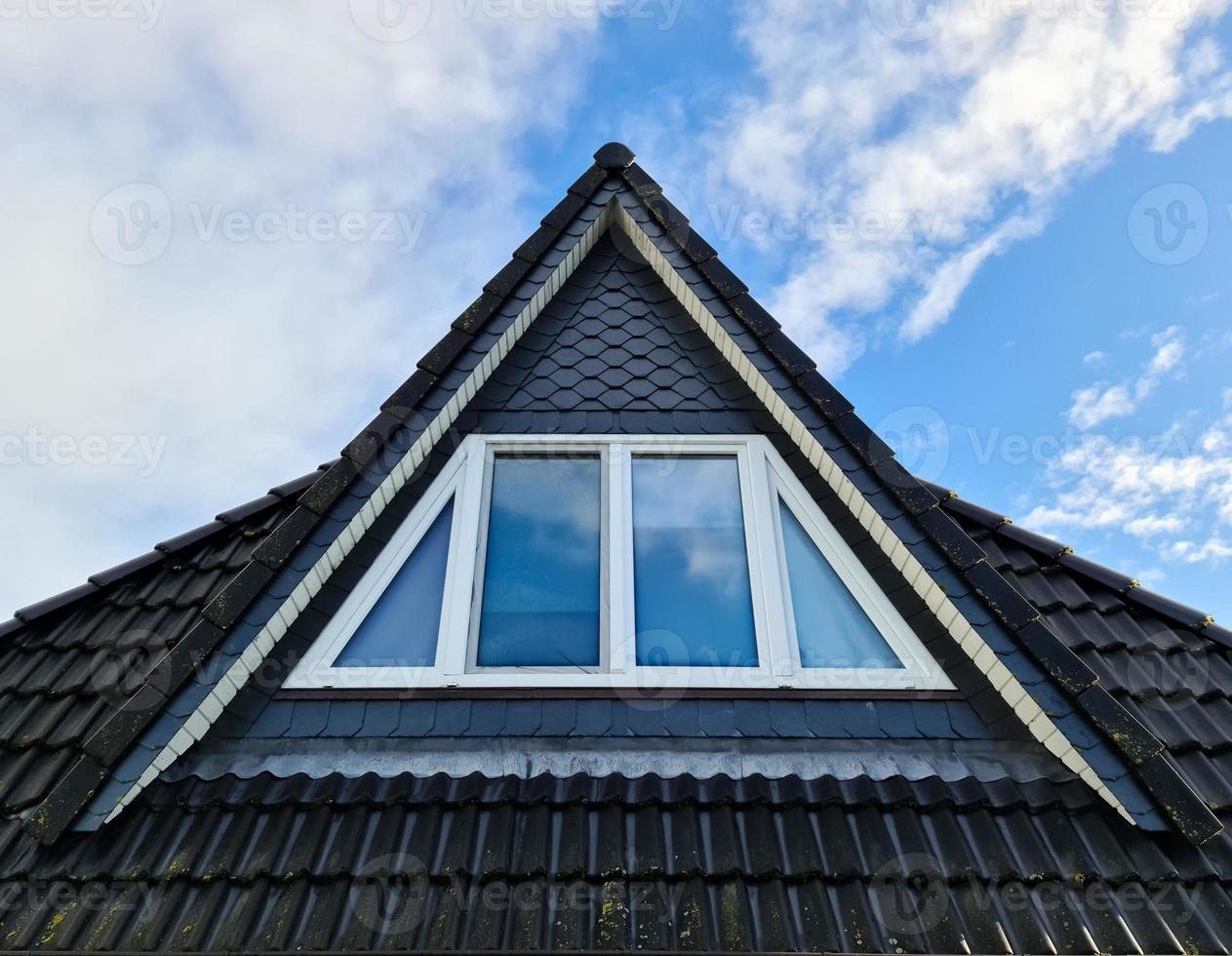 Open roof window in velux style with black roof tiles. photo