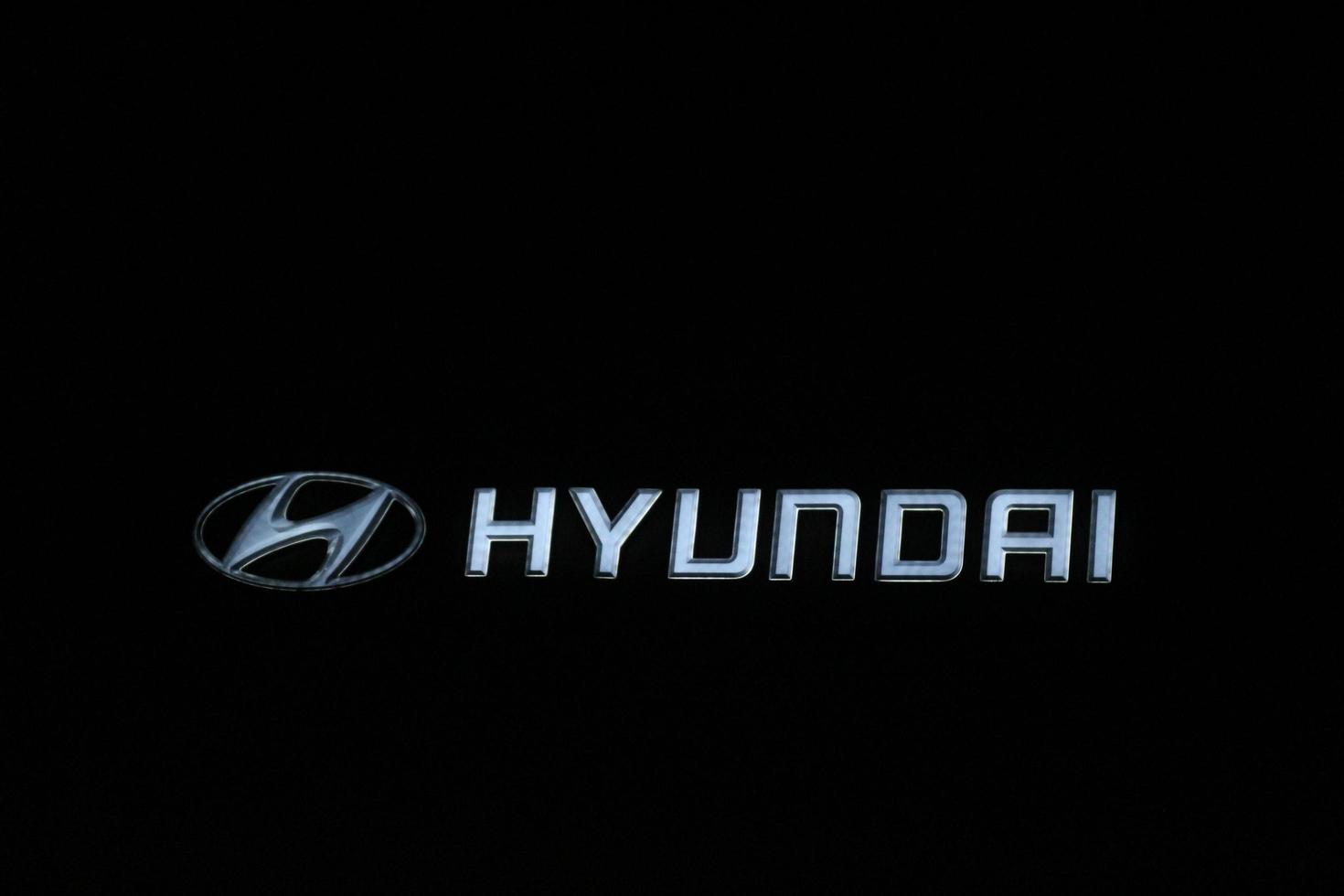 Bekasi, Indonesia in July 2022. The HYUNDAI logo shining brightly at night against the dark night sky. photo