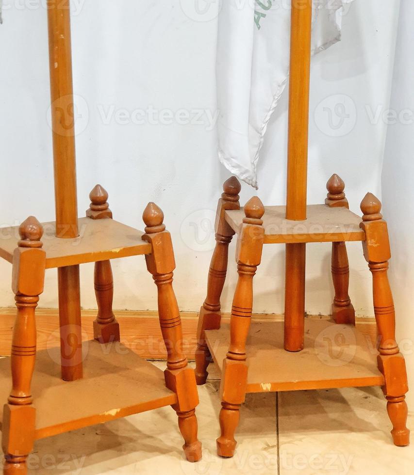 Photo of an indoor flagpole stand made of wood. It has four legs as a solid base so it doesn't fall easily.