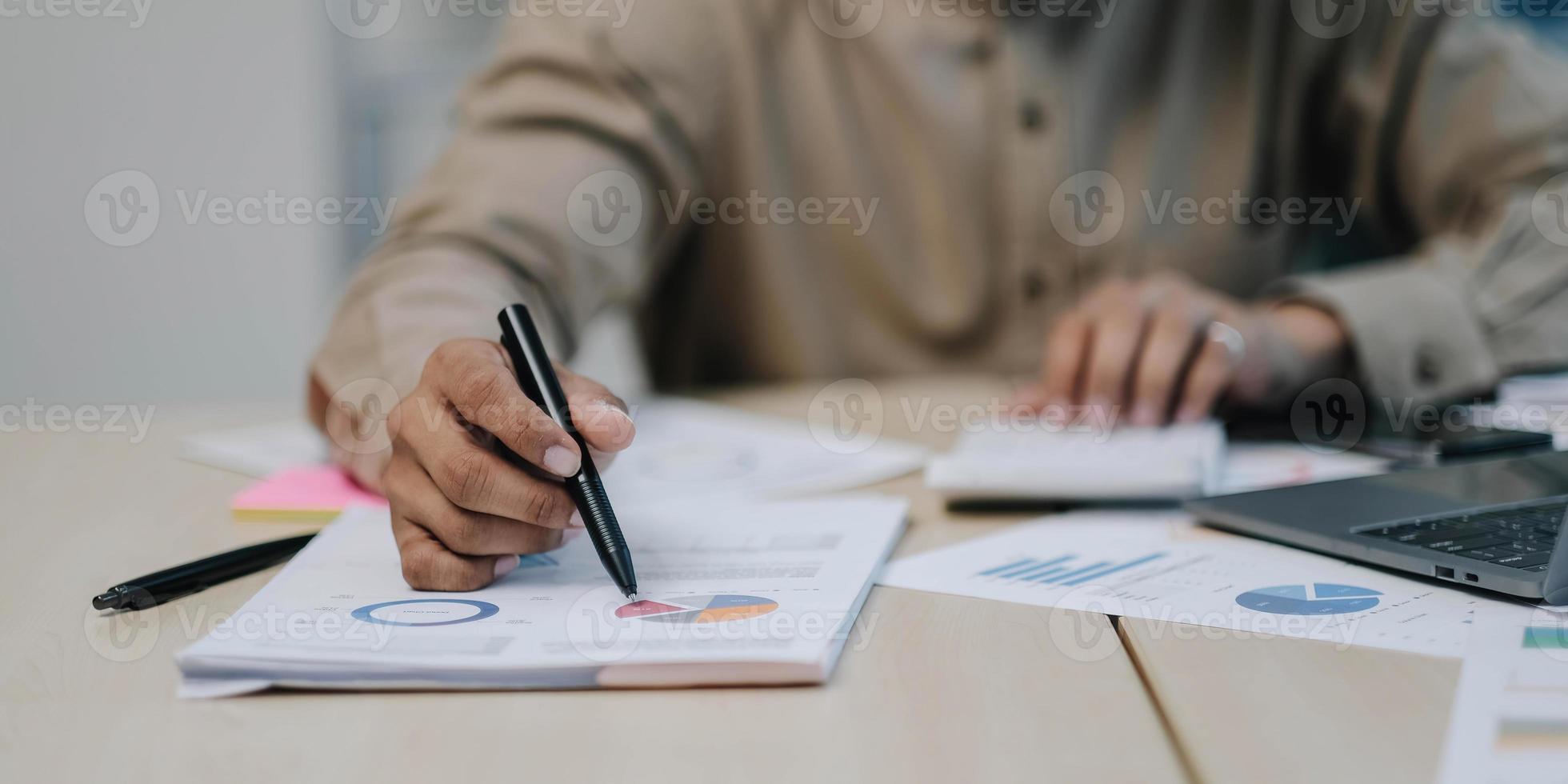 Close-up of the hands of a businessman using a calculator to check financial accounts check the company's expenses and budget. photo