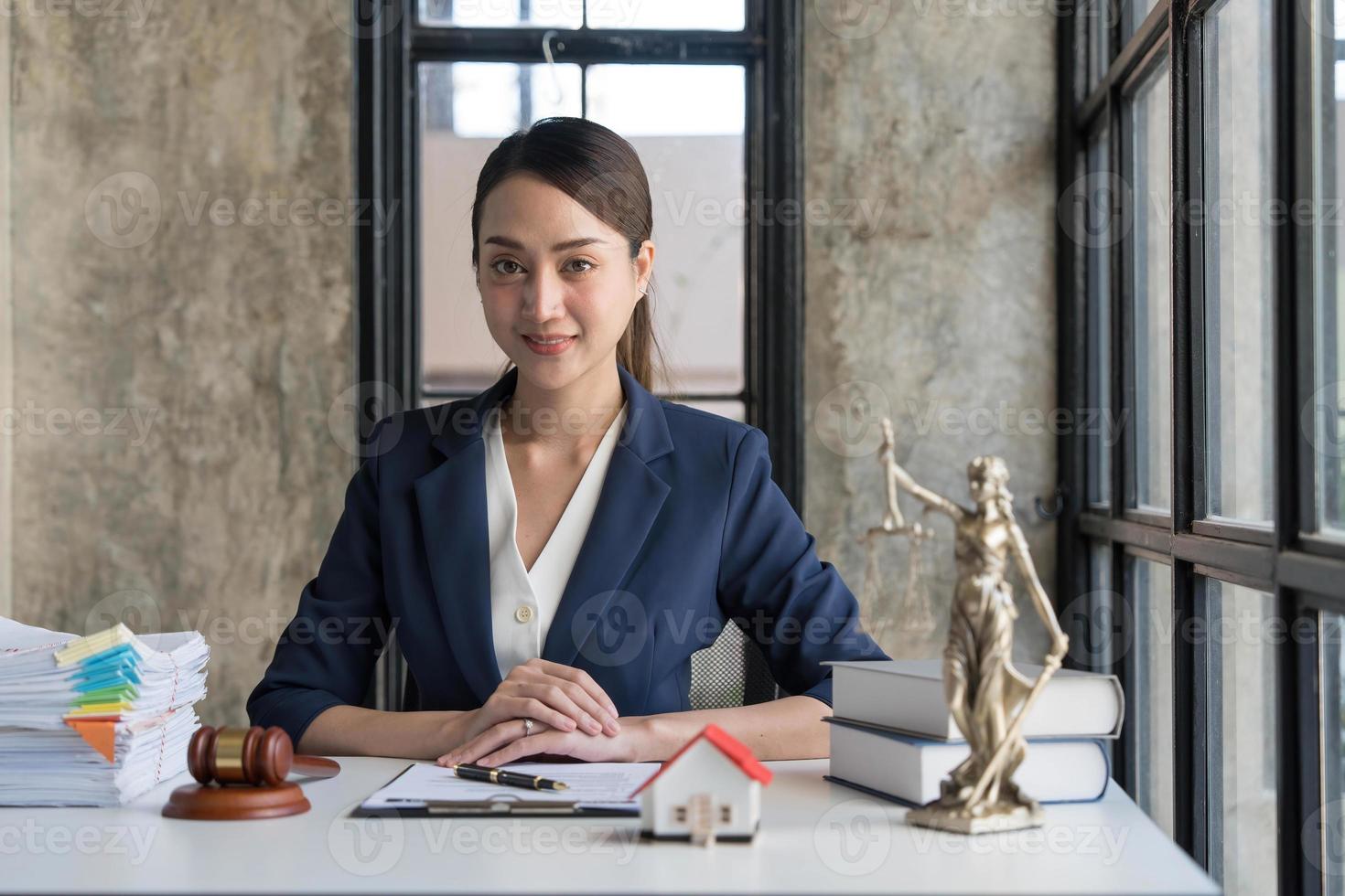 mujer de negocios o abogados que trabajan en un escritorio de madera en la oficina. ley, servicios legales, asesoramiento, subasta de jueces y concepto de bienes raíces. foto