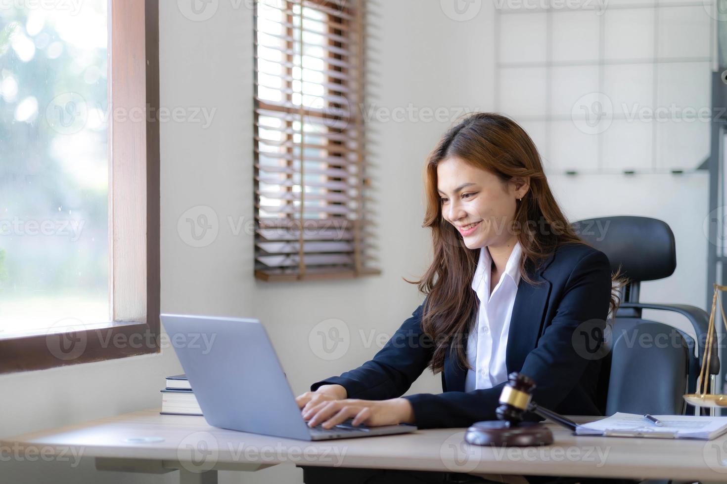 Beautiful asian woman lawyer working and gavel, tablet, laptop in front, Advice justice and law concept. photo
