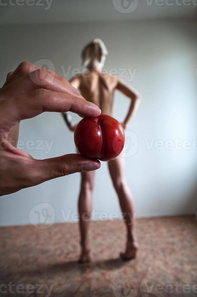 the hand holding the fruit on the background of the girls photo