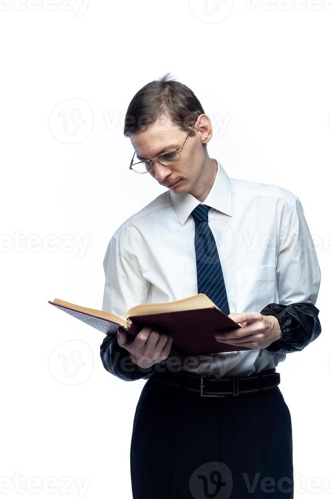 A business man in a tie and glasses with a magazine in his hands on a white, isolated background photo