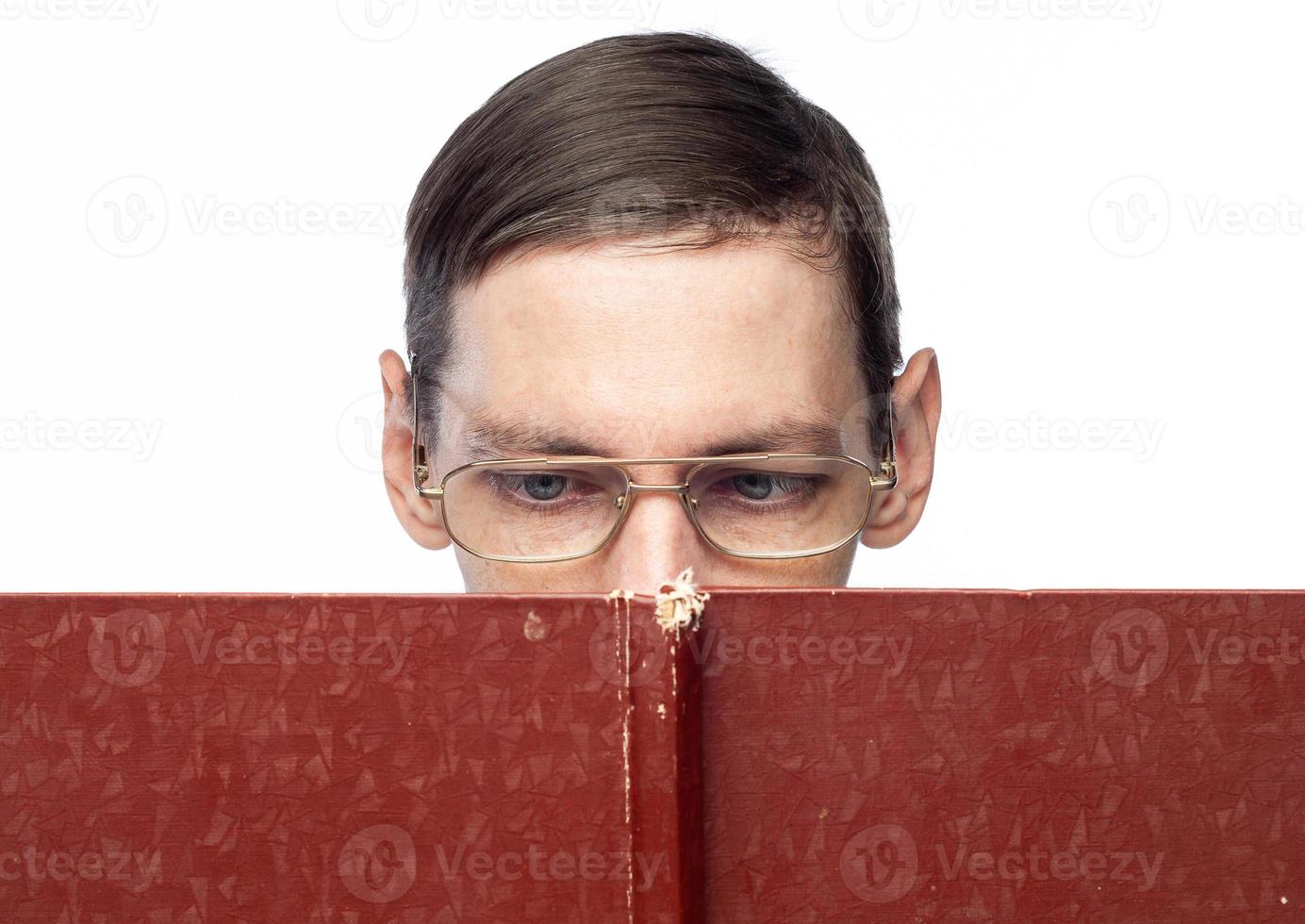 The man's face is covered by a large red notebook, on an isolated background photo