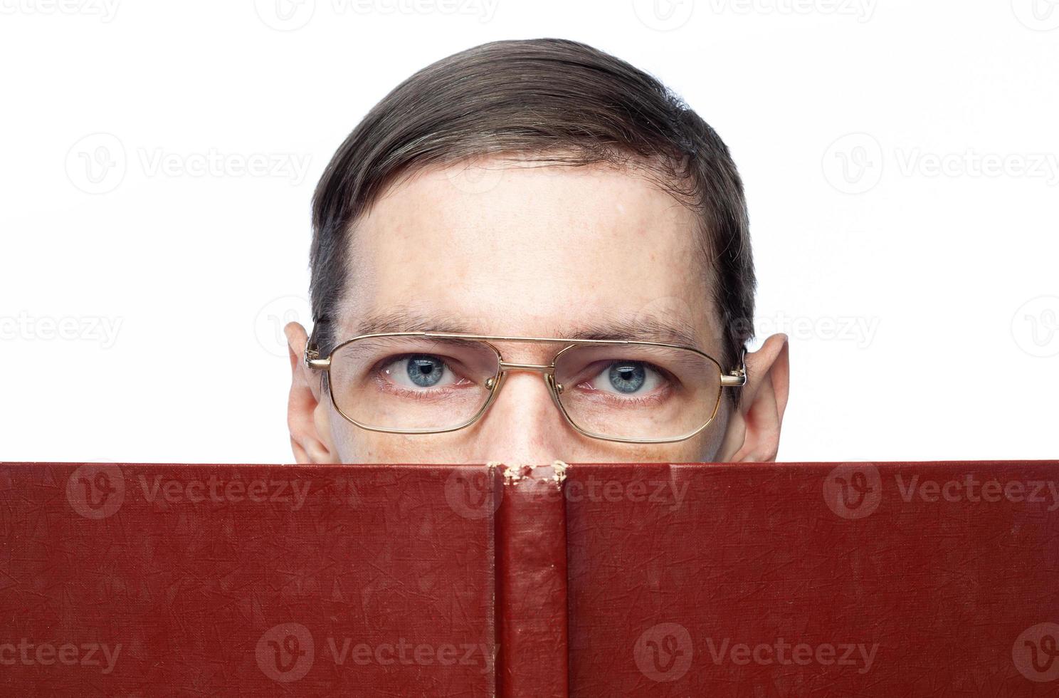 The man's face is covered by a large red notebook, on an isolated background photo