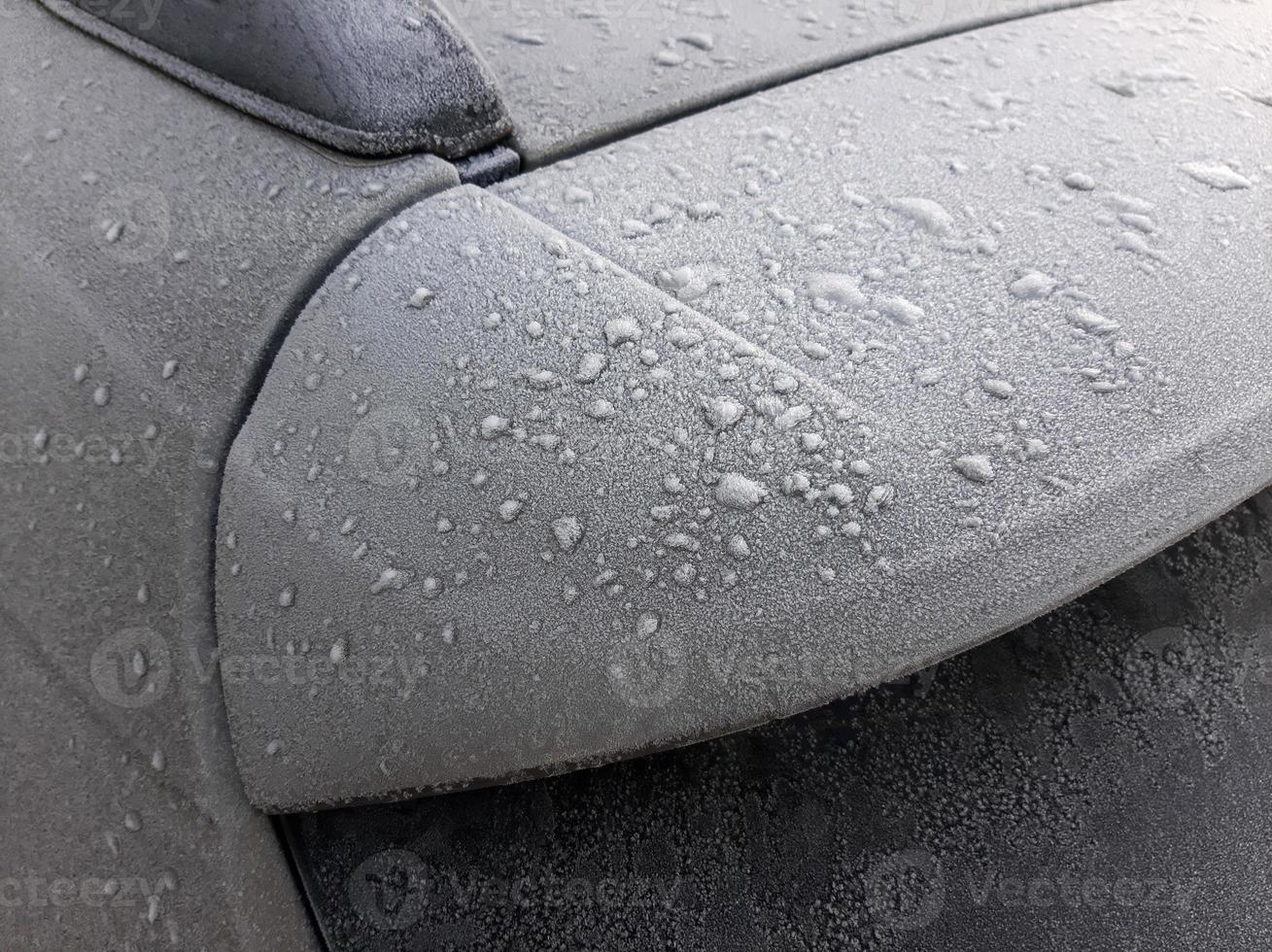 Snow covered car window with wipers, macro, close up photo