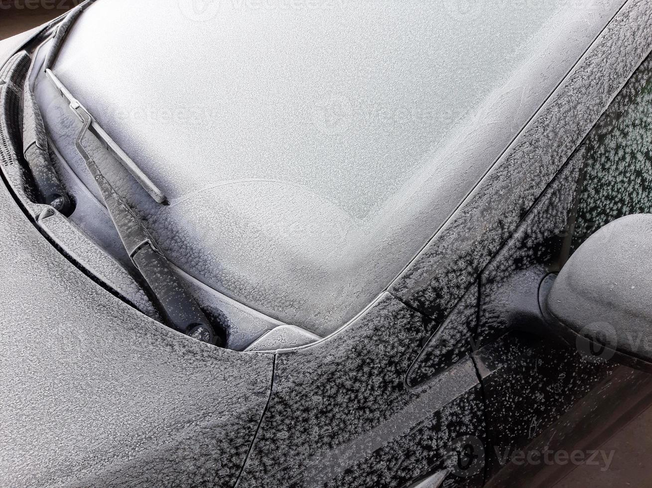 Snow covered car window with wipers, macro, close up photo