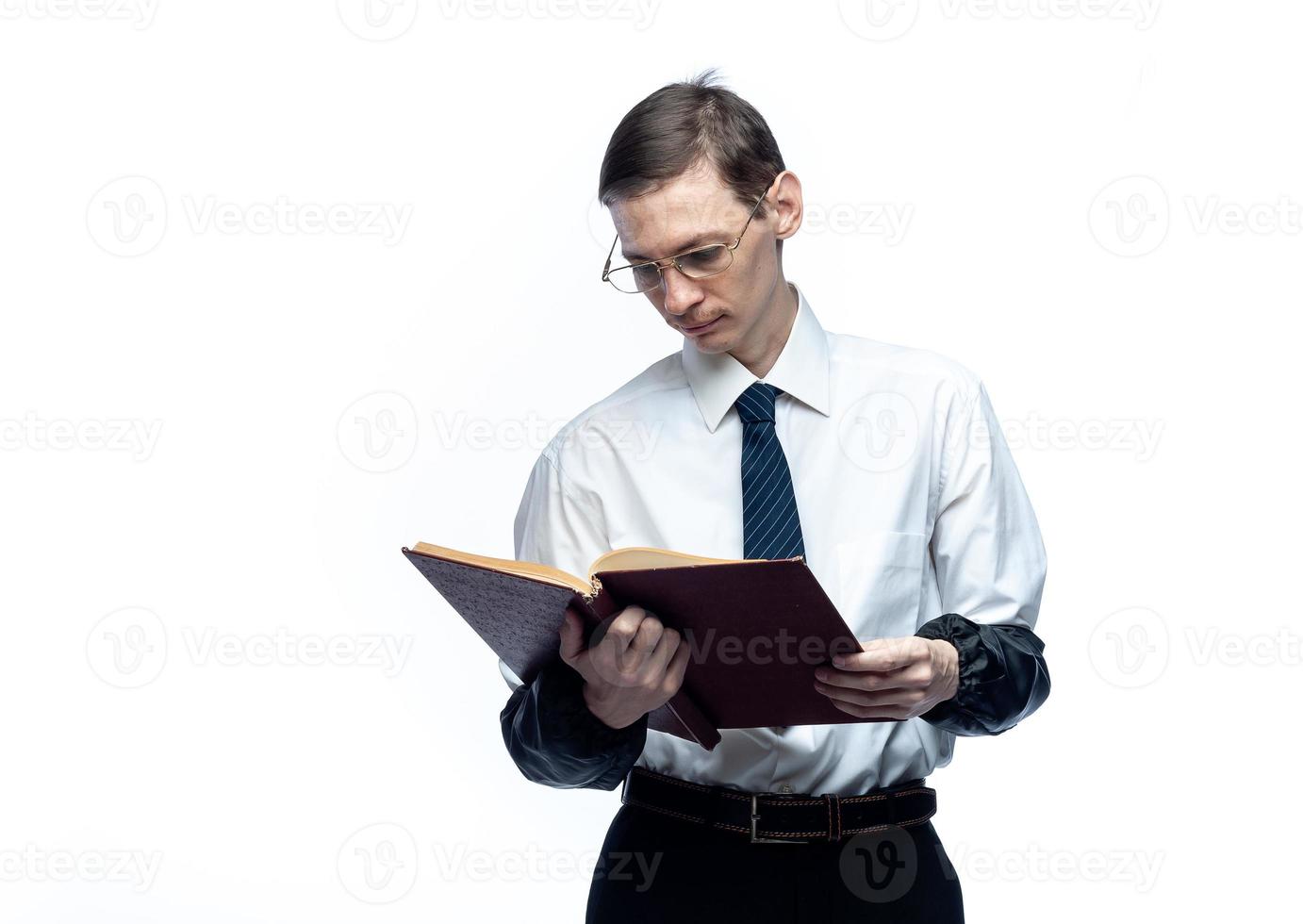 un hombre de negocios con corbata y gafas con una revista en las manos sobre un fondo blanco y aislado foto