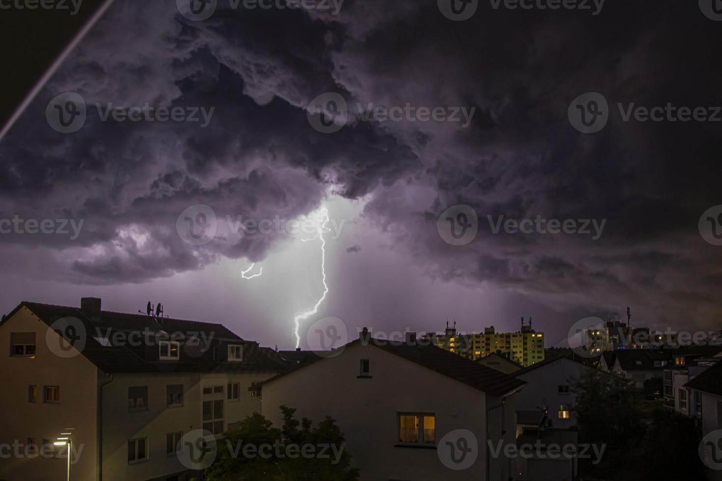 imagen de un rayo sobre edificios con formaciones de nubes amenazantes foto