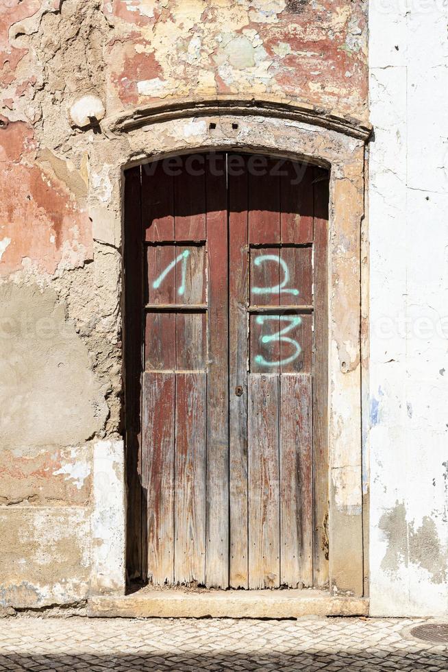 Old and dirty entry-door of an abandoned house in Portugal photo