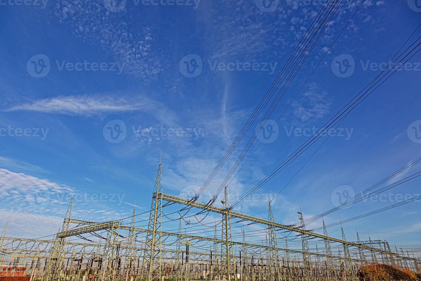 Picture of a transformer station with many insulators and cables during the day photo