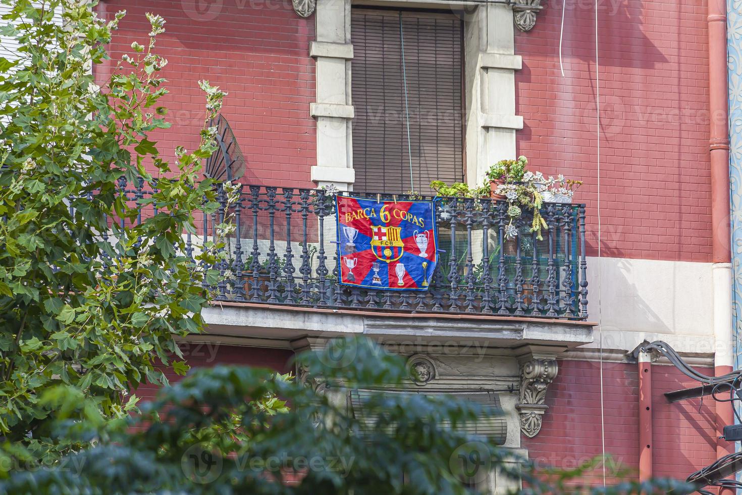 View of a balcony with cast iron railing and Barca flag attached to it photo