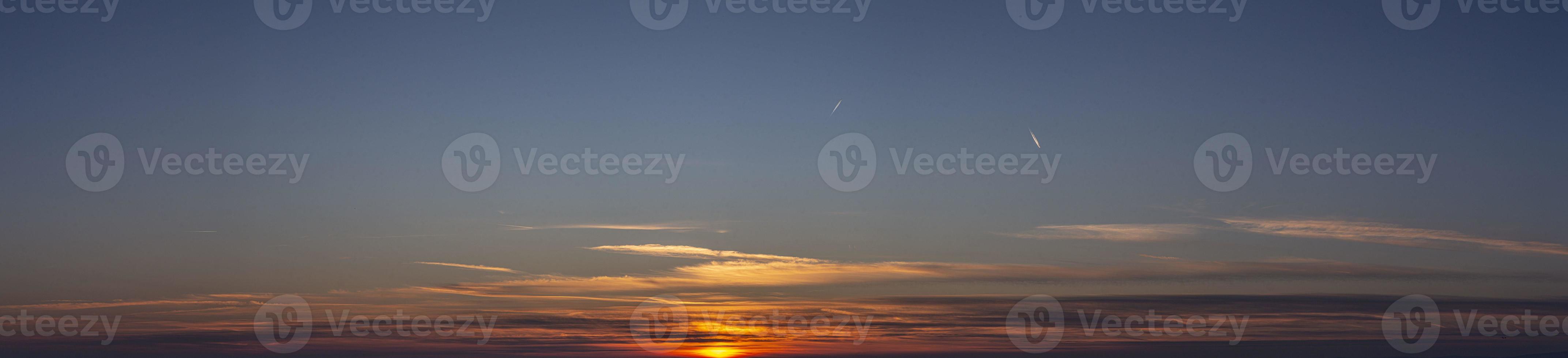 imagen de cielo dramático y colorido con sol durante la puesta de sol foto