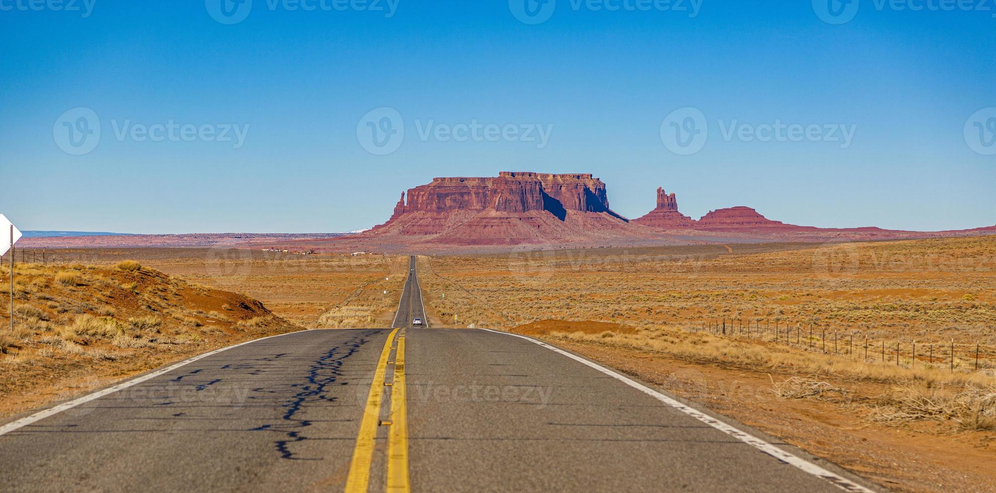 Panoramic picture of endless road in front of majestic rock formation in the Monument Valley National park in winter photo
