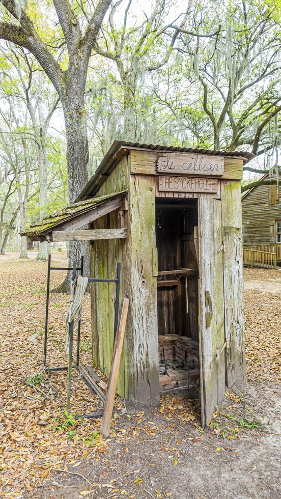 Old and damaged wooden cabin in the Louisiana forest during daytime photo