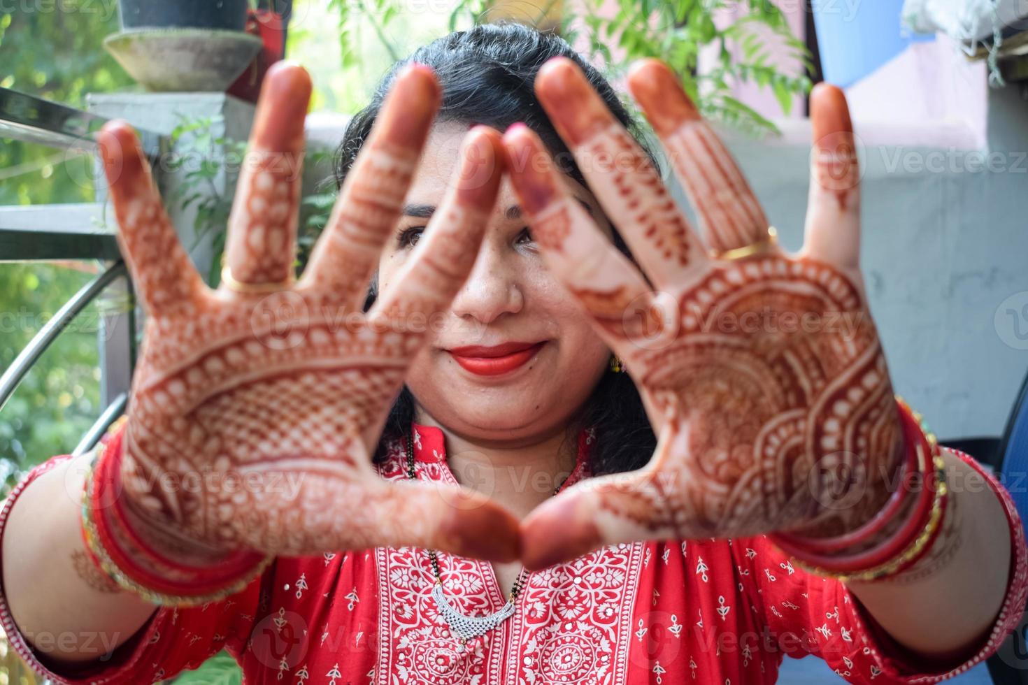 Beautiful woman dressed up as Indian tradition with henna mehndi design on her both hands to celebrate big festival of Karwa Chauth, Karwa Chauth celebrations by Indian woman for her husband photo