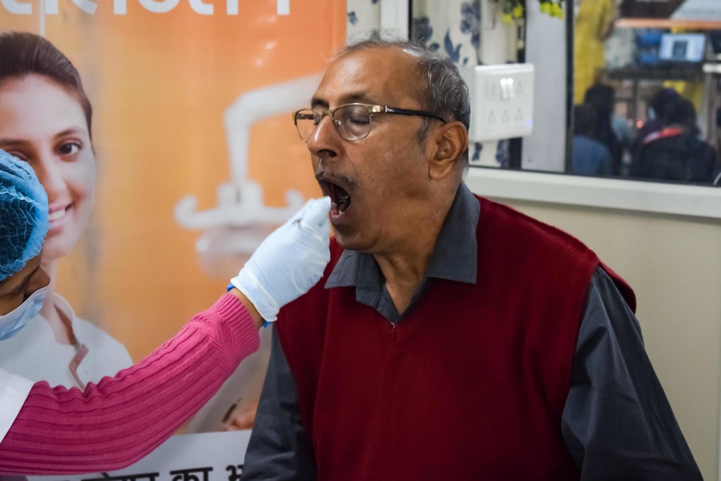 Delhi, India - November 19, 2022 - Close up of female dentist doing routine dental check-up to patient, Patient lying on chair at annual health check-up, Dentist doing dental check-up to patient photo