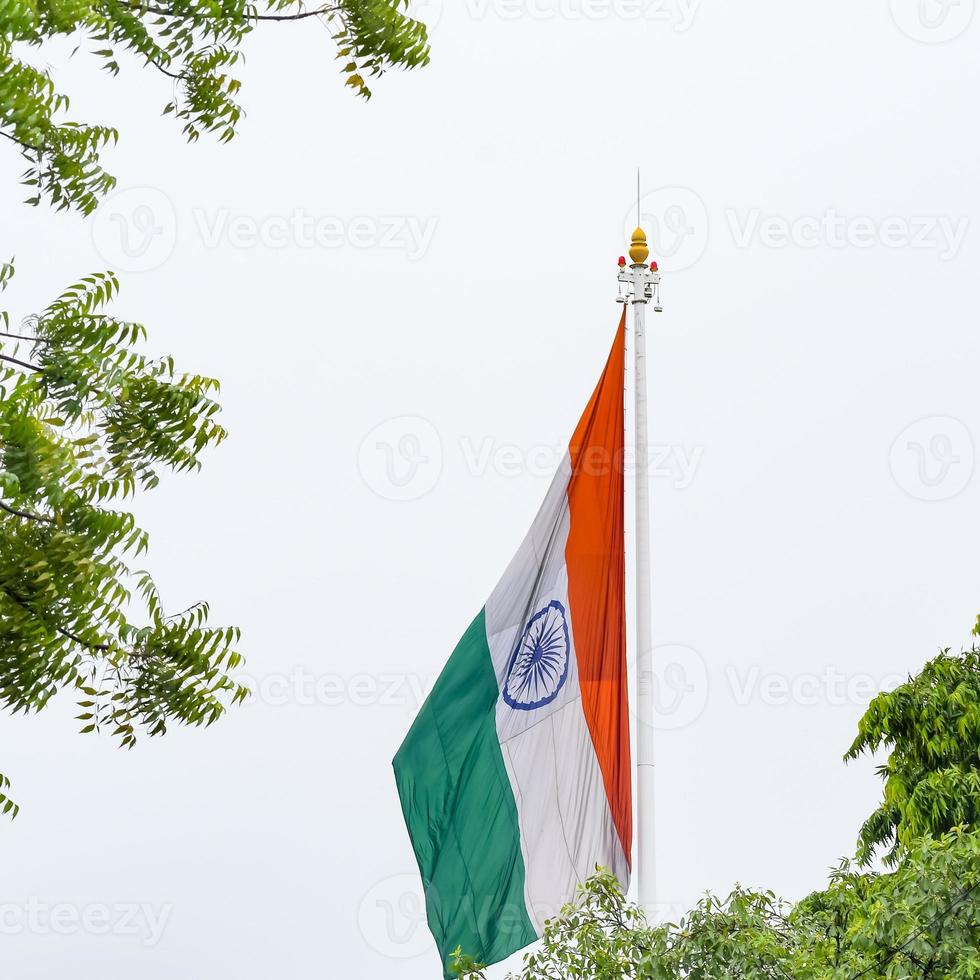 India flag flying high at Connaught Place with pride in blue sky, India flag fluttering, Indian Flag on Independence Day and Republic Day of India, tilt up shot, Waving Indian flag, Har Ghar Tiranga photo