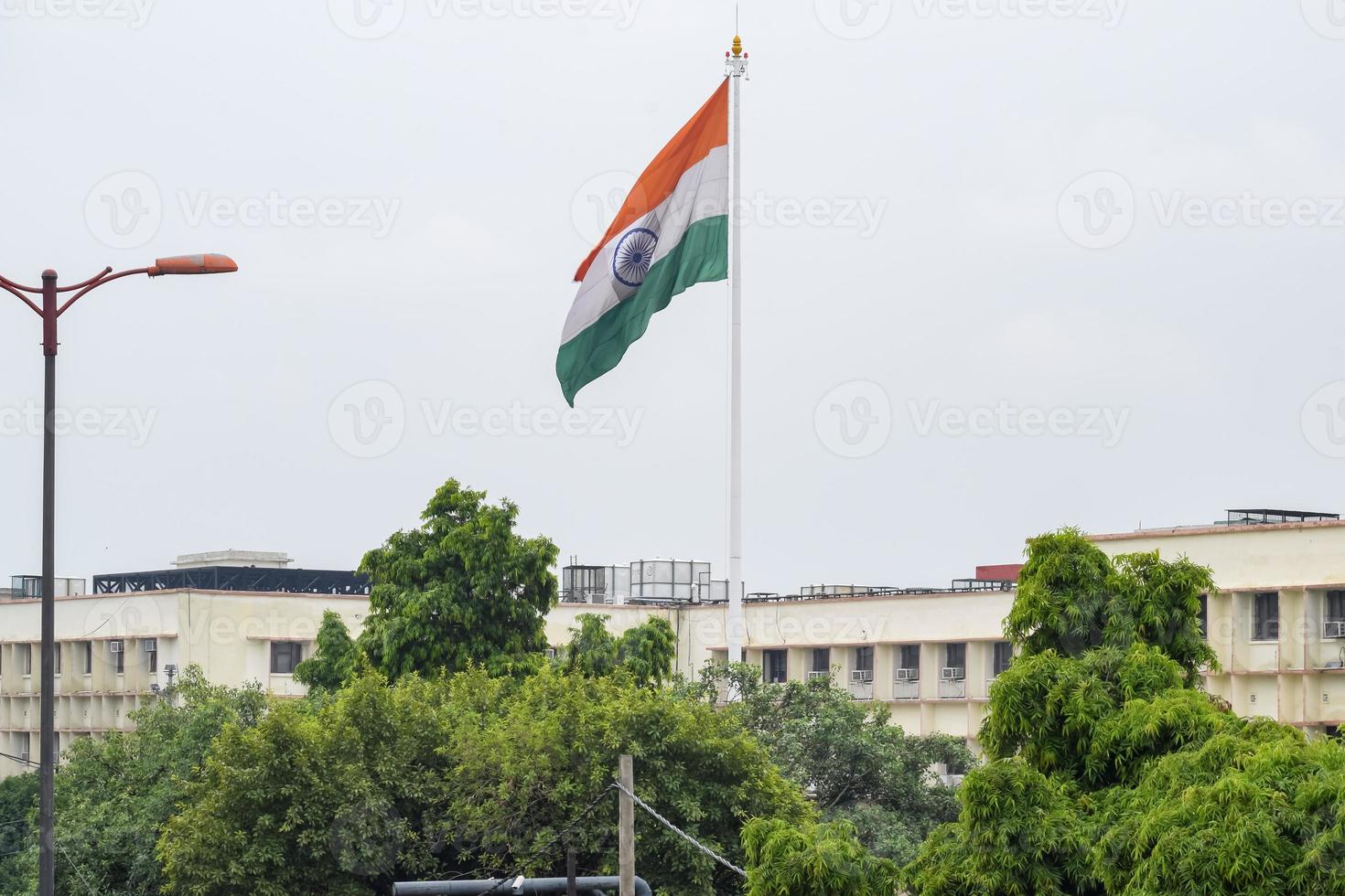 India flag flying high at Connaught Place with pride in blue sky, India flag fluttering, Indian Flag on Independence Day and Republic Day of India, tilt up shot, Waving Indian flag, Har Ghar Tiranga photo