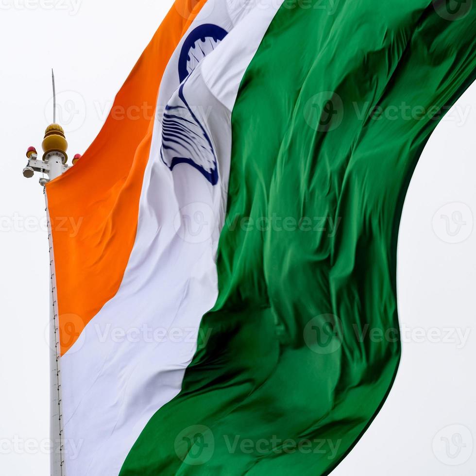 India flag flying high at Connaught Place with pride in blue sky, India flag fluttering, Indian Flag on Independence Day and Republic Day of India, tilt up shot, Waving Indian flag, Har Ghar Tiranga photo