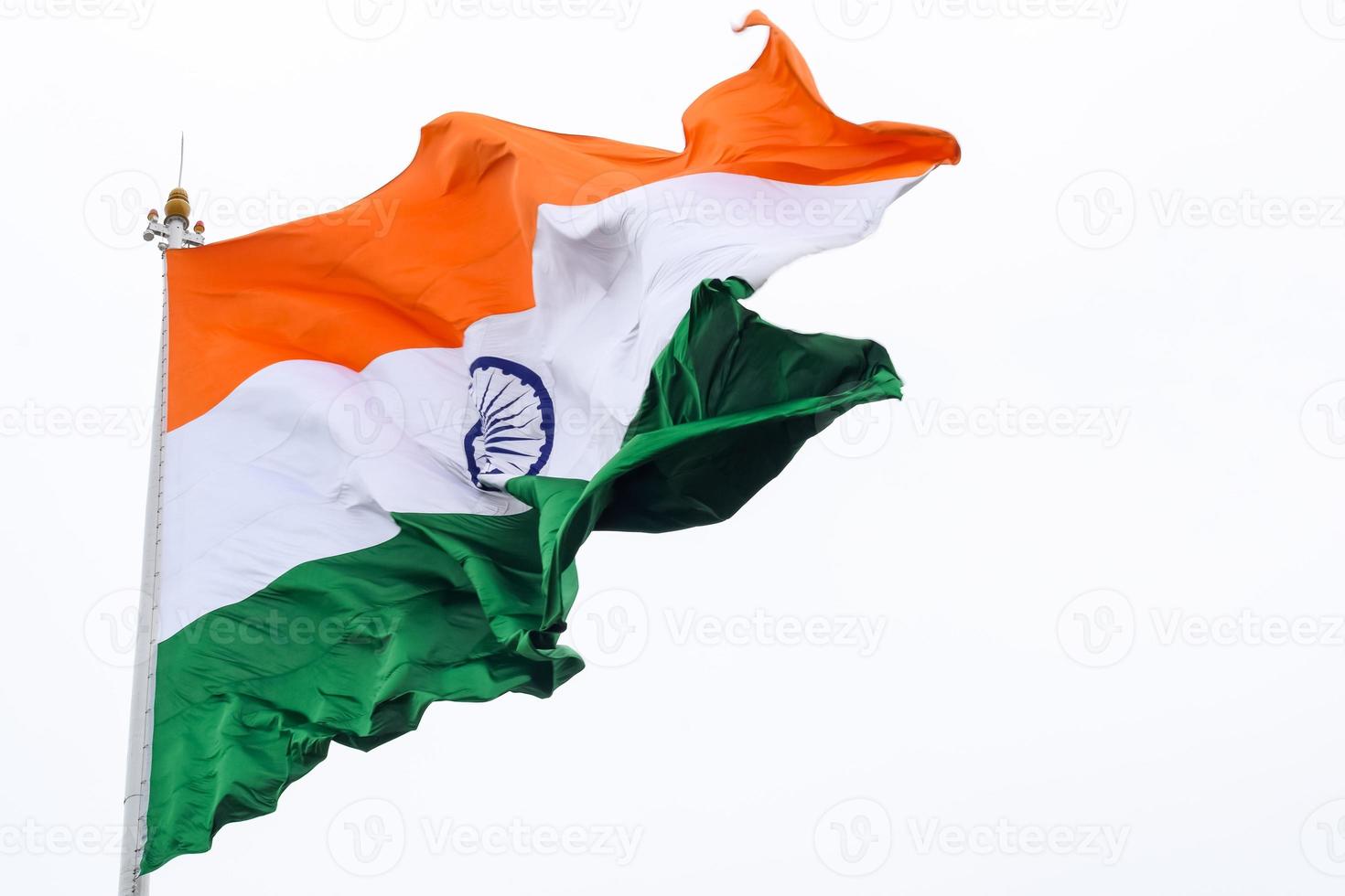 India flag flying high at Connaught Place with pride in blue sky, India flag fluttering, Indian Flag on Independence Day and Republic Day of India, tilt up shot, Waving Indian flag, Har Ghar Tiranga photo