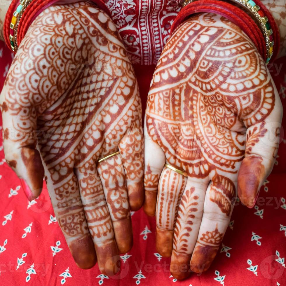 hermosa mujer vestida como tradición india con diseño de henna mehndi en ambas manos para celebrar el gran festival de karwa chauth, celebraciones de karwa chauth de una mujer india para su marido foto