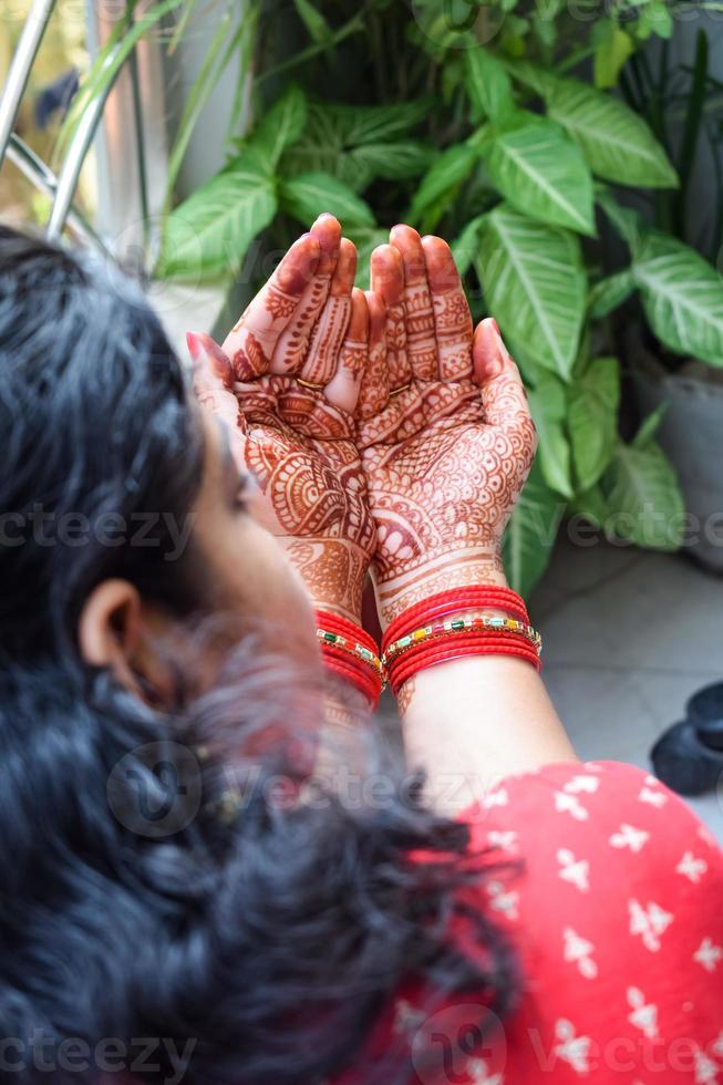 Beautiful woman dressed up as Indian tradition with henna mehndi design on her both hands to celebrate big festival of Karwa Chauth, Karwa Chauth celebrations by Indian woman for her husband photo