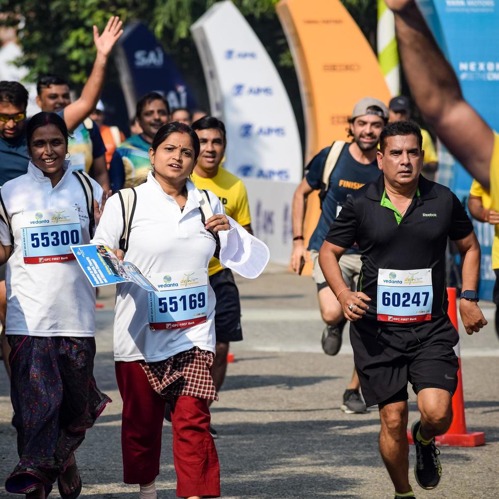 New Delhi, India - October 16 2022 - Vedanta Delhi Half Marathon race after covid in which marathon participants about to cross the finish line, Delhi Half Marathon 2022 photo