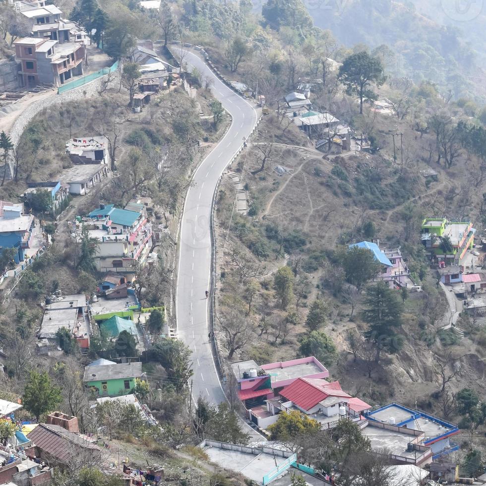 Aerial top view of traffic vehicles driving at mountains roads at Nainital, Uttarakhand, India, View from the top side of mountain for movement of traffic vehicles photo