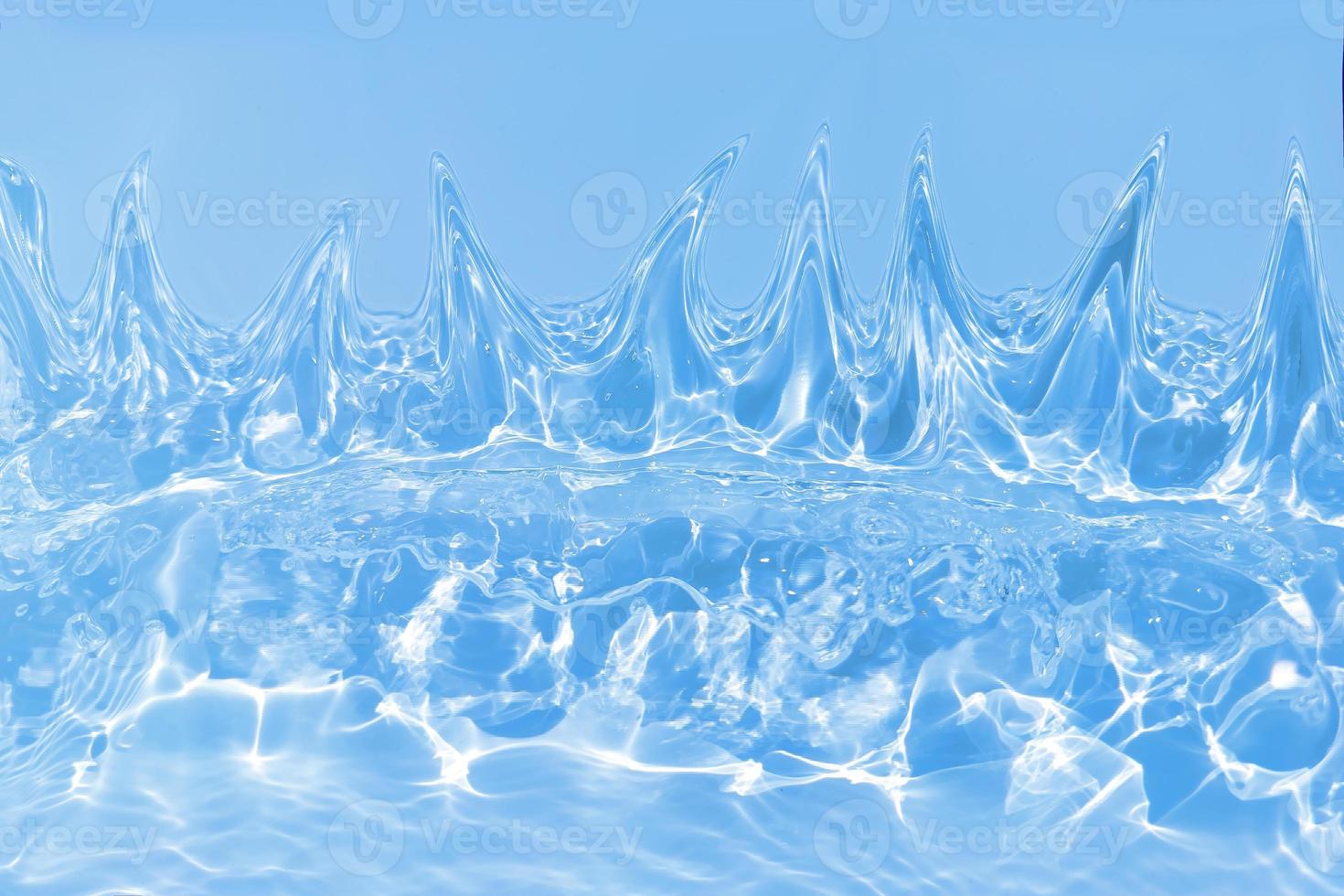 Defocus blurred transparent blue colored clear calm water surface texture with splashes and bubbles. Trendy abstract nature background. Water waves in sunlight with caustics. Blue water shinning photo